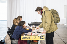 910725 Afbeelding van iemand die zijn stem uitbrengt tijdens de Gemeenteraadsverkiezingen van Utrecht van 2018.